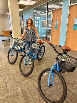 woman with three bikes in library